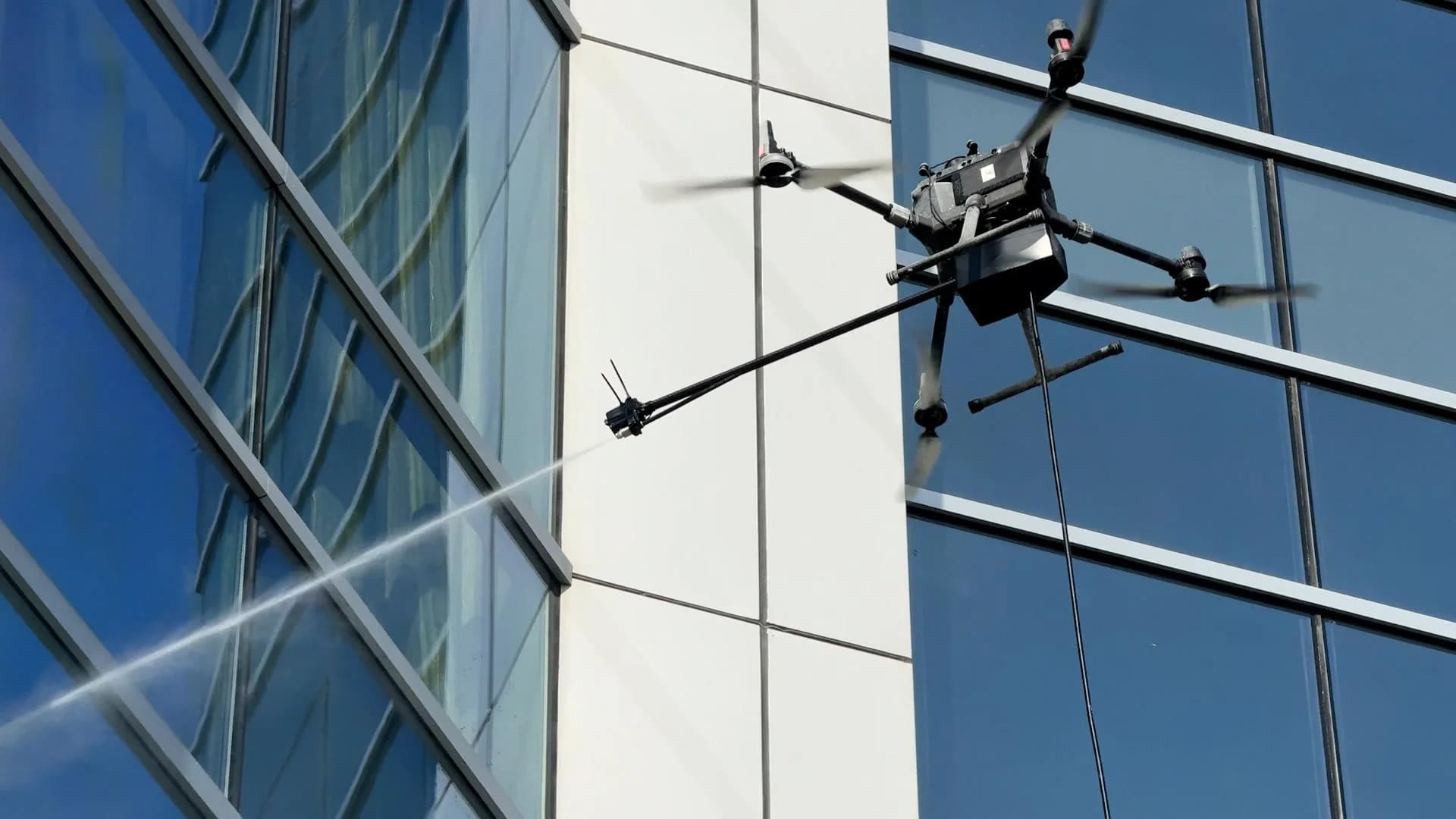 Yüksek katlı bir yapının cam cephesini temizleyen drone